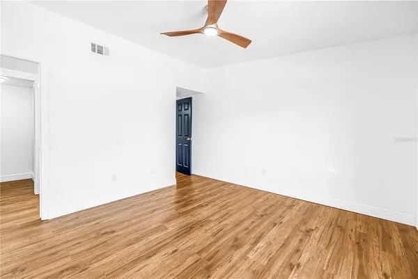 a view of empty room with wooden floor