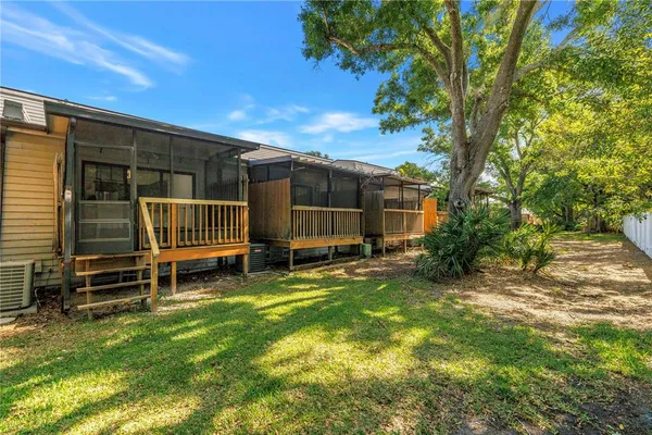 a view of a swimming pool with a yard and wooden fence