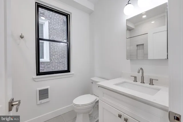 a bathroom with a sink toilet and mirror