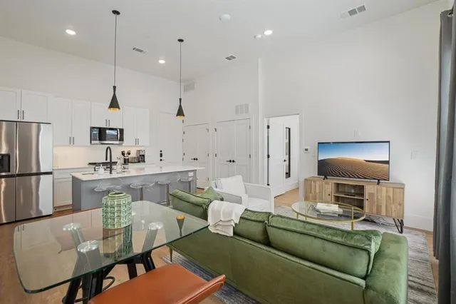 a living room with furniture a refrigerator and kitchen view