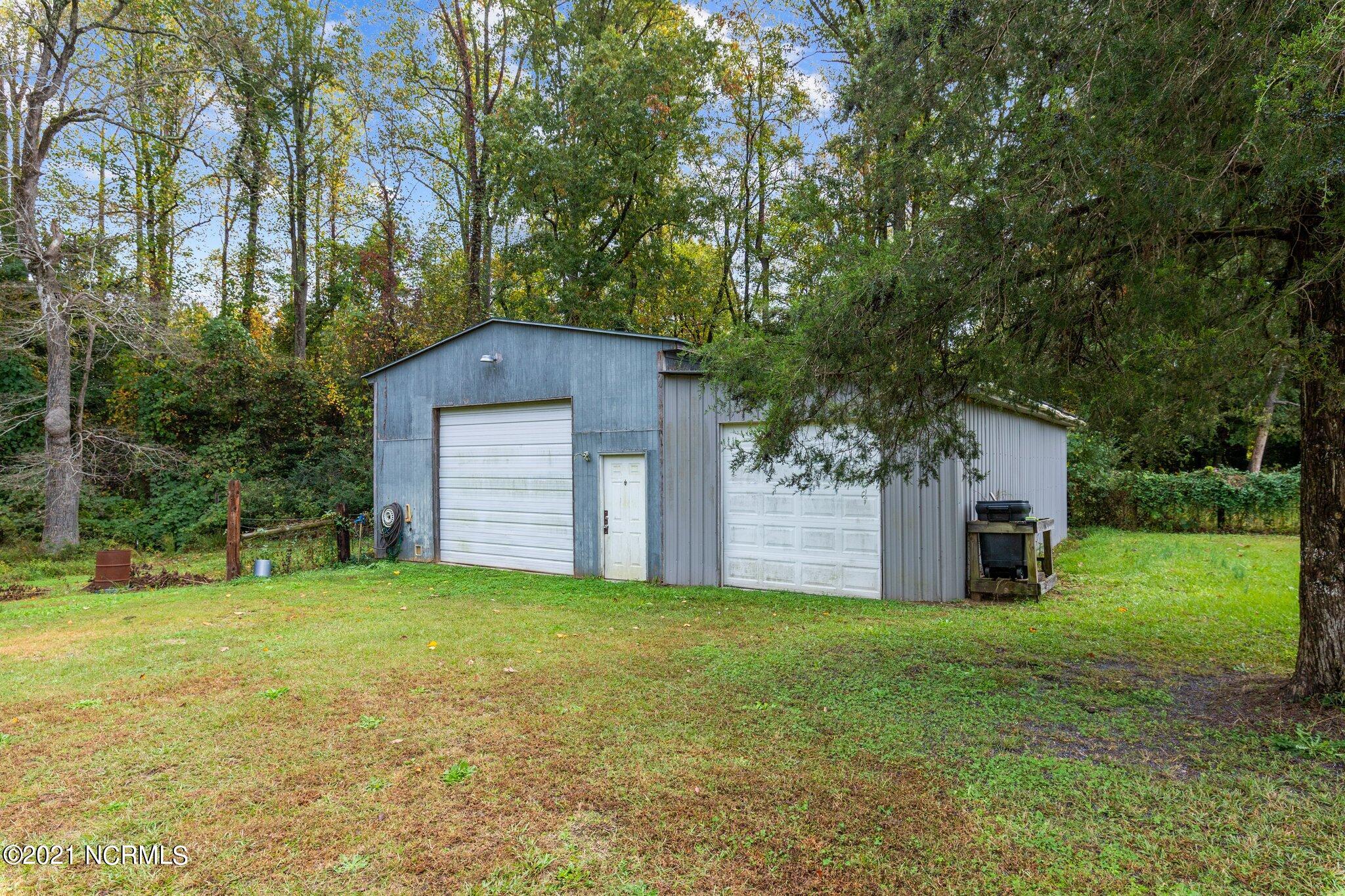1477 Farm Life School Road Carthage, NC 28327 - Photo 9 of 32 Spacious back yard leads to detached garage and workshop. Approx. 38.5 ft x 36 ft = Approx. 1386 square feet of unheated garage/workshop area!