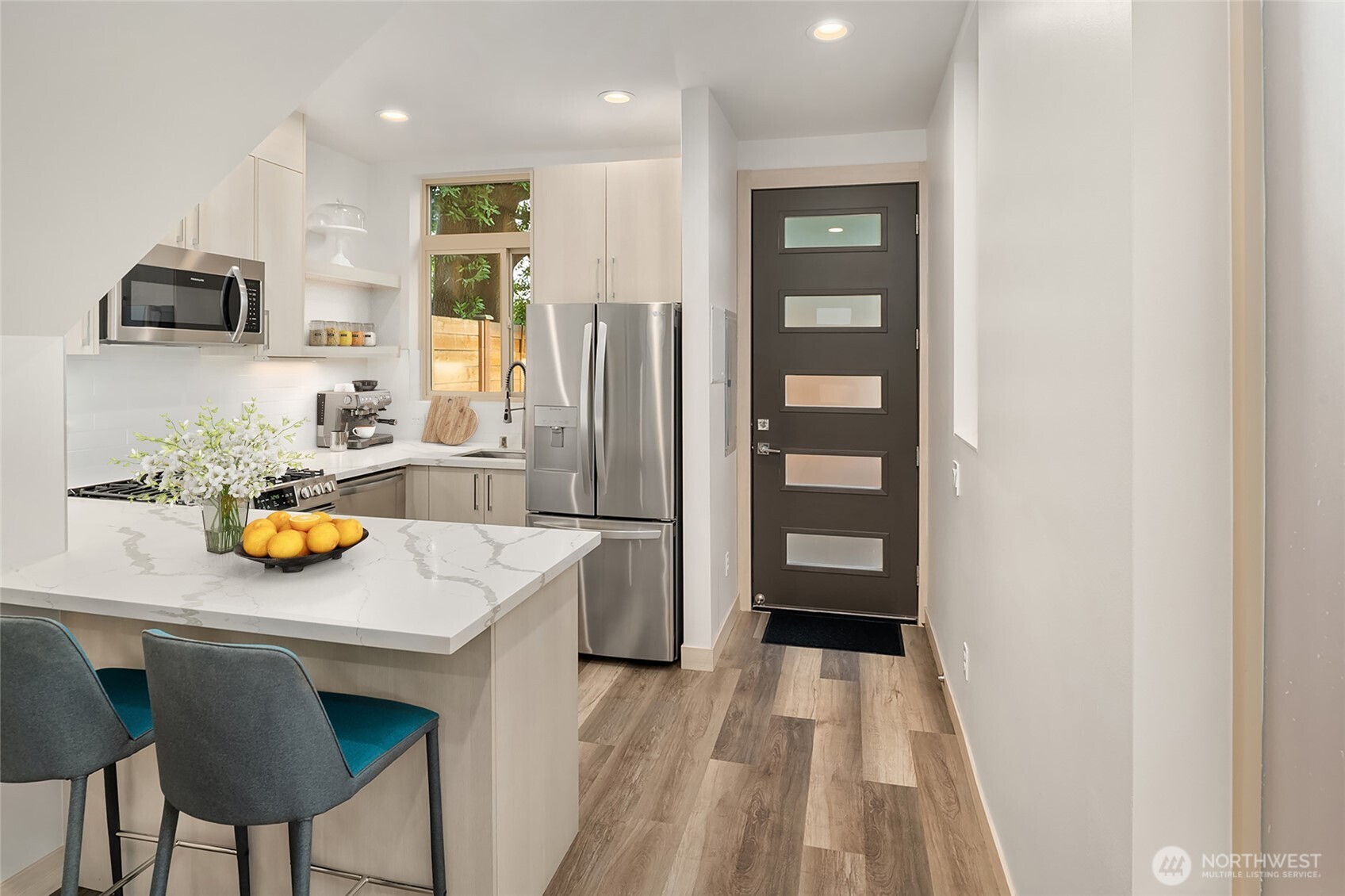 5616 California Avenue Southwest, Unit C Seattle, WA 98136 - Photo 8 of 36 a kitchen with stainless steel appliances a refrigerator a sink a stove and a refrigerator with wooden floor