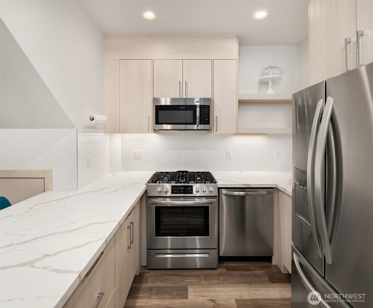 5616 California Avenue Southwest, Unit C Seattle, WA 98136 - Photo 9 of 36 a kitchen with stainless steel appliances a stove a microwave and a refrigerator