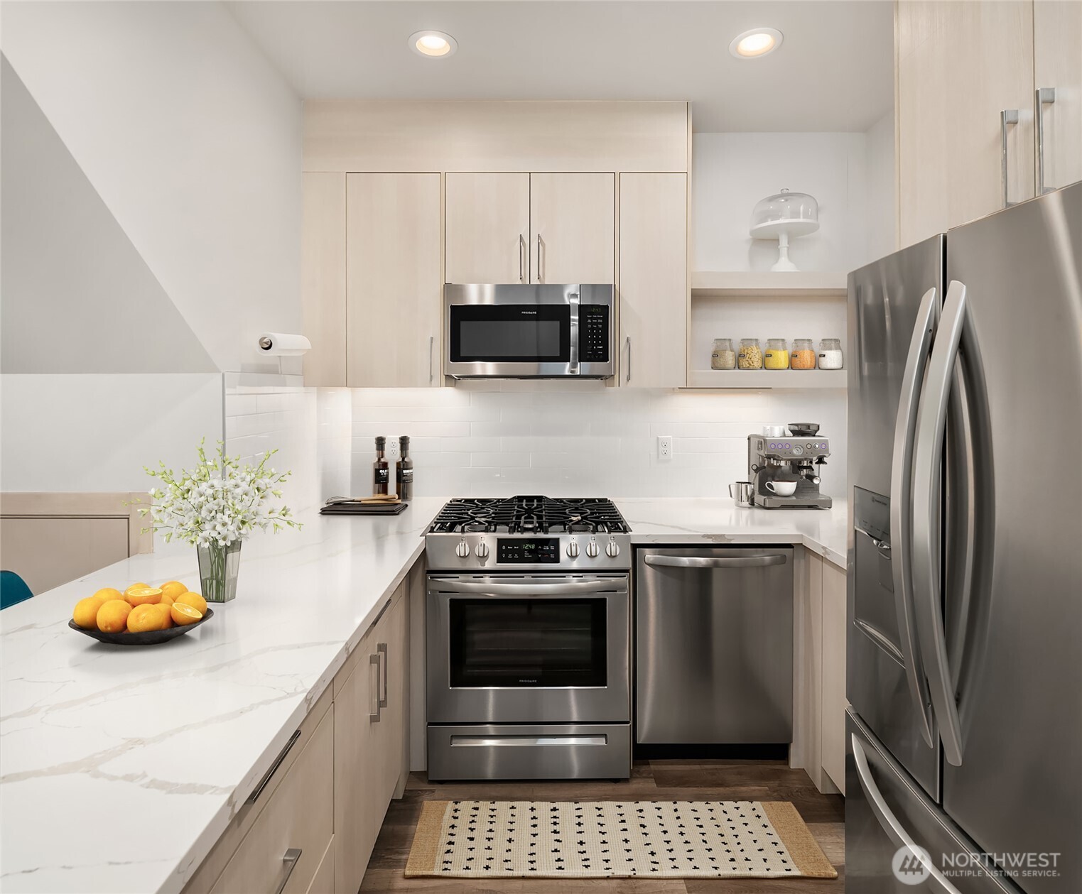 5616 California Avenue Southwest, Unit C Seattle, WA 98136 - Photo 10 of 36 a kitchen with stainless steel appliances a stove a microwave and a refrigerator