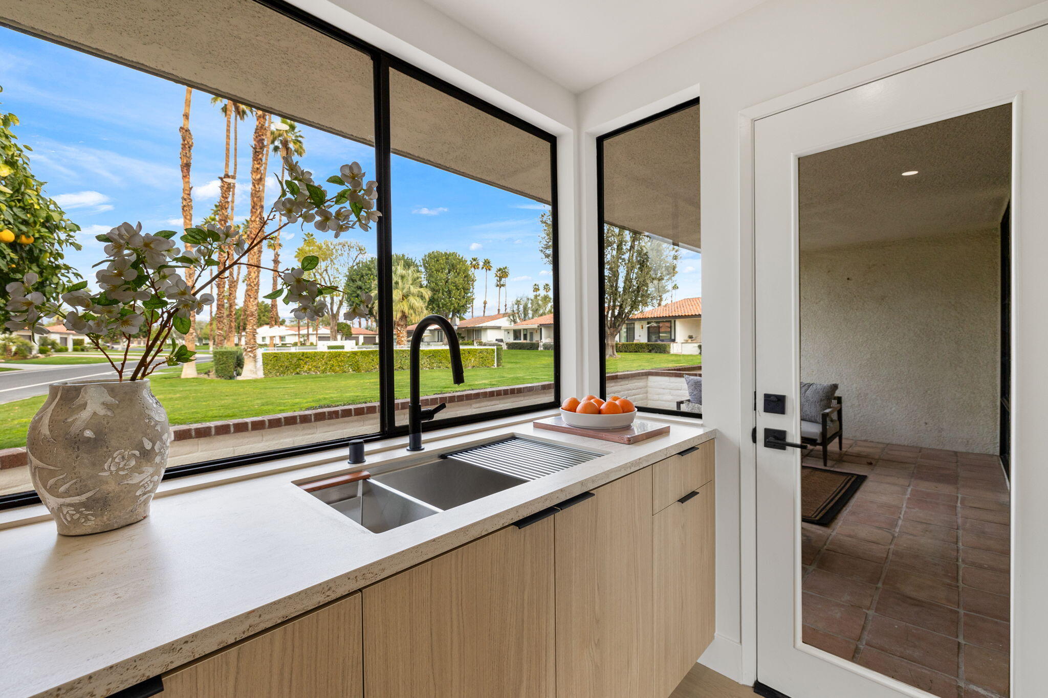 2 Leon Way Rancho Mirage, CA 92270 - Photo 13 of 55 a kitchen with a sink and a large mirror