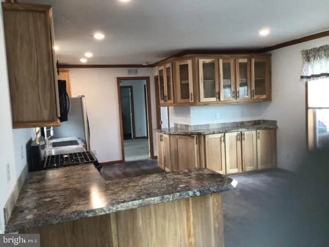 a kitchen with kitchen island granite countertop a stove and a sink