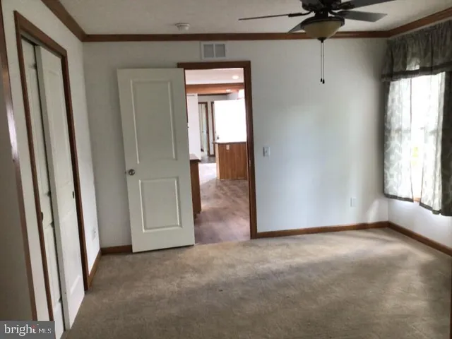 an empty room with windows and closet