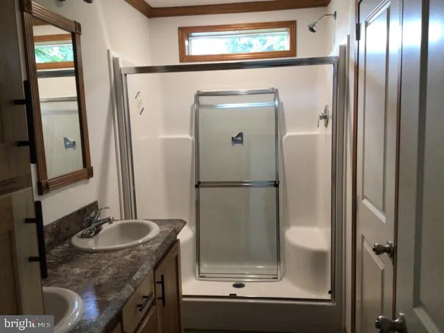 a bathroom with a sink a mirror and a shower