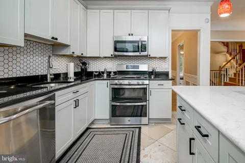 a kitchen with granite countertop a stove sink and cabinets