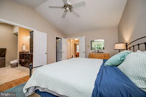 a bedroom with a large bed and wooden floor