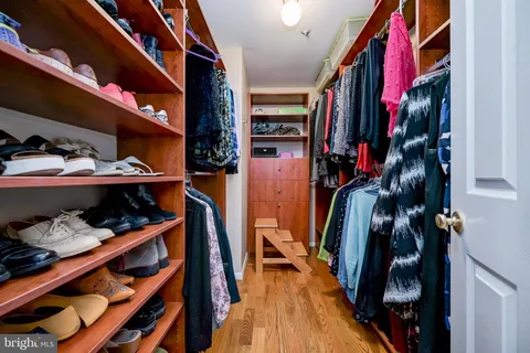 a view of walk in closet with clothes and shoes