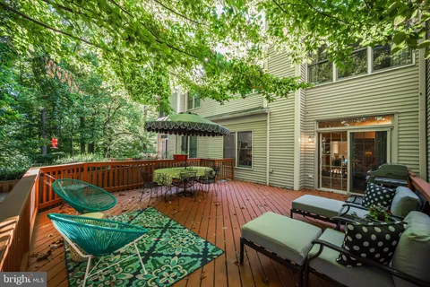 a view of a patio with couches chairs and a table and chairs with wooden floor