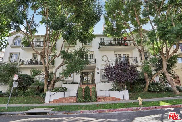 a view of a house with a yard and large trees