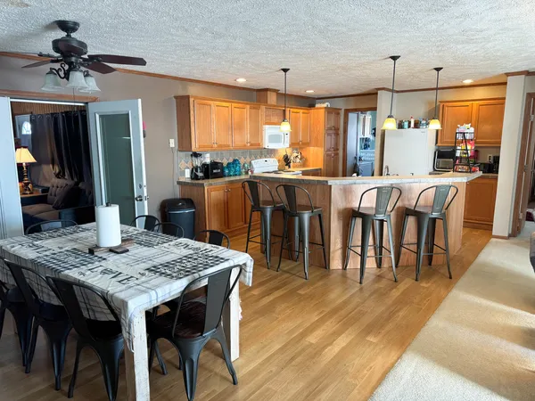 a kitchen with a refrigerator a stove top oven a counter space and wooden floor
