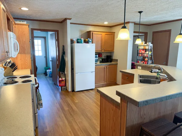 a kitchen with kitchen island granite countertop a sink a counter top space appliances and cabinets