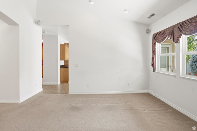 2190 750 West Perry, UT 84302 - Photo 14 of 42 Bright interior space featuring recessed lighting, a window with exterior views, and a doorway opening to an additional room with wood-finish cabinetry