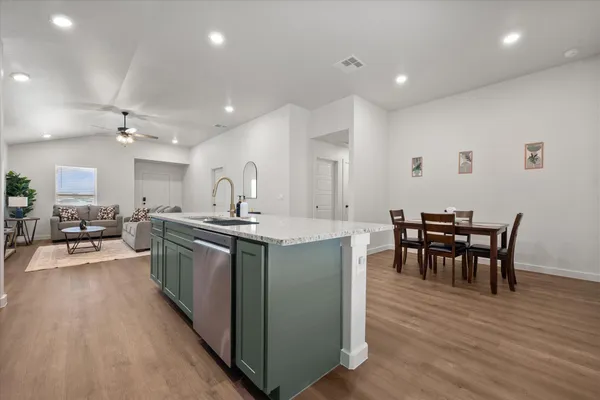a kitchen with stainless steel appliances granite countertop a stove and a wooden floors