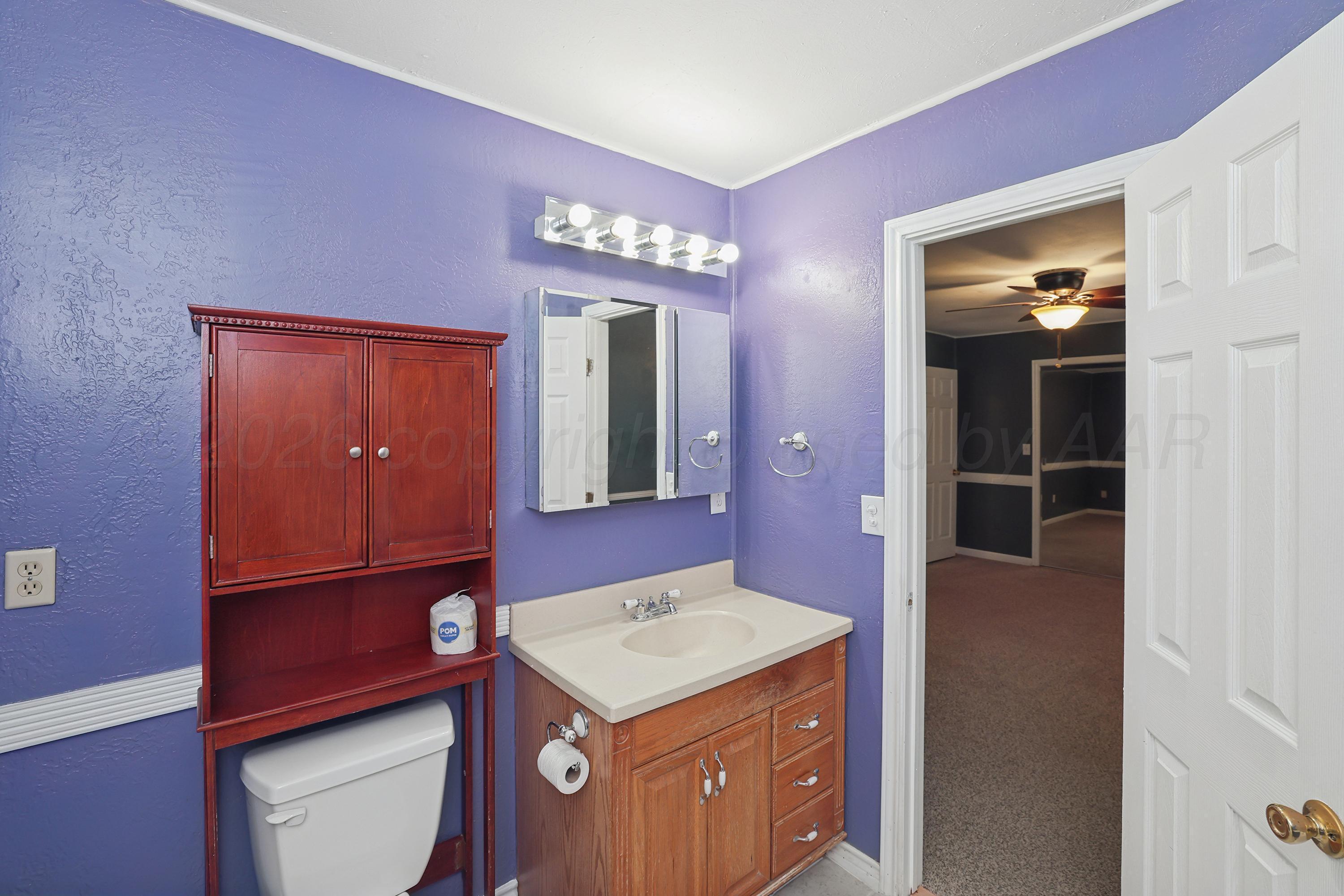 14200 Savannah Road Amarillo, TX 79118 - Photo 15 of 34 a bathroom with a sink a mirror and a toilet