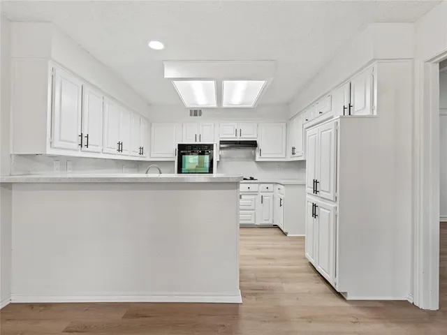 a kitchen with stainless steel appliances a refrigerator sink and white cabinets