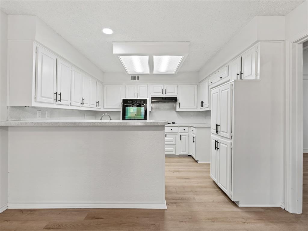 4028 St Christopher Lane Dallas, TX 75287 - Photo 13 of 29 a kitchen with stainless steel appliances a refrigerator sink and white cabinets