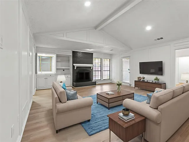 a living room with furniture a flat screen tv and a fireplace