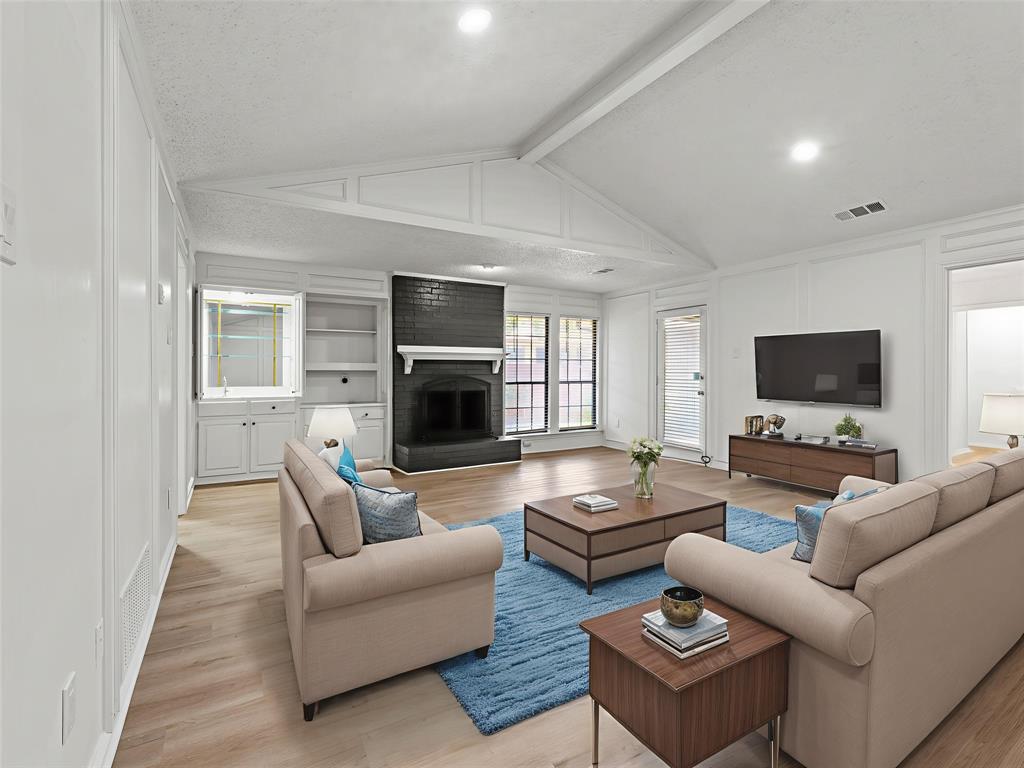 4028 St Christopher Lane Dallas, TX 75287 - Photo 2 of 29 a living room with furniture a flat screen tv and a fireplace