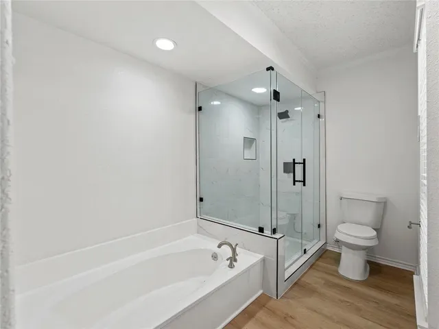 a bathroom with a granite countertop sink a toilet and shower
