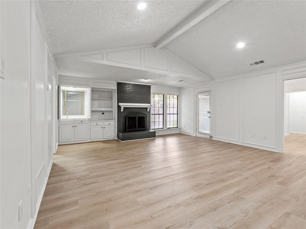 4028 St Christopher Lane Dallas, TX 75287 - Photo 3 of 29 an empty room with wooden floor fire place and windows