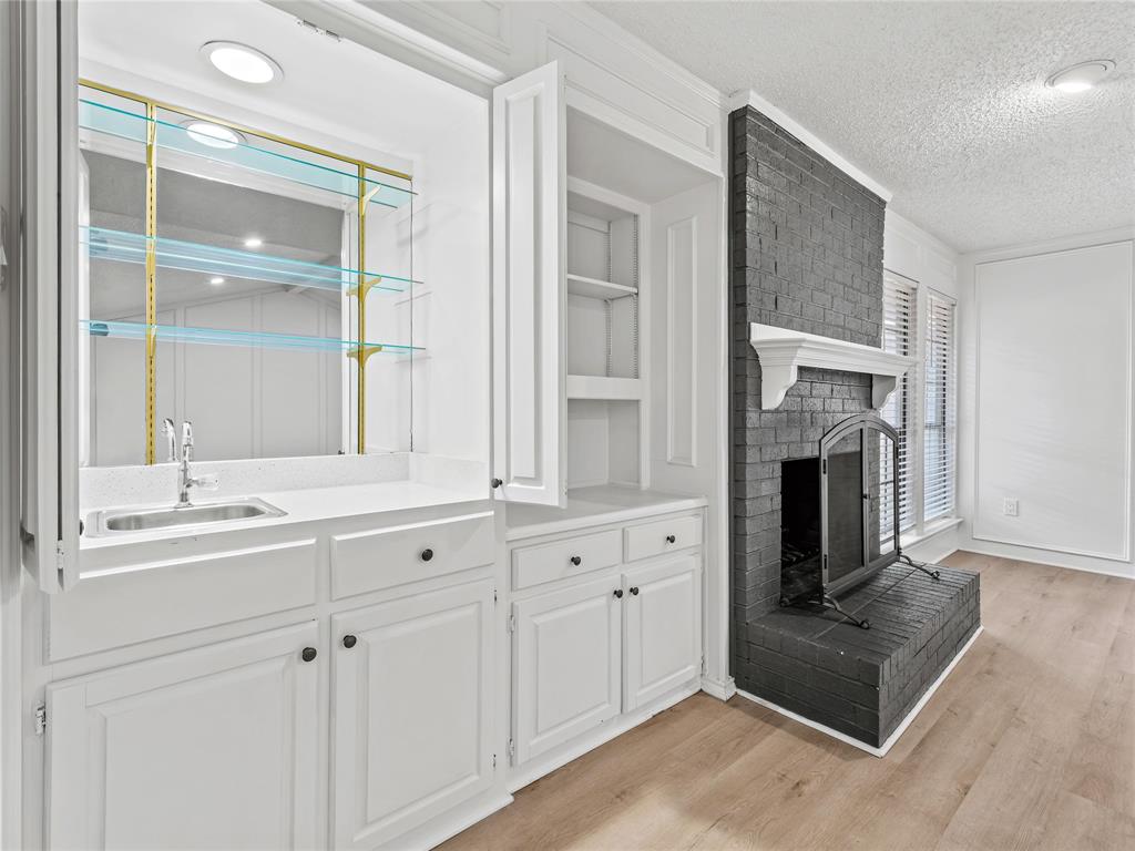 4028 St Christopher Lane Dallas, TX 75287 - Photo 5 of 29 a kitchen with cabinets and a fireplace