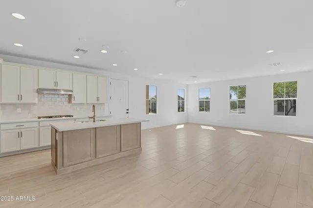 a kitchen with white cabinets and sink