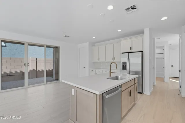 a view of a kitchen with white cabinets and wooden floor