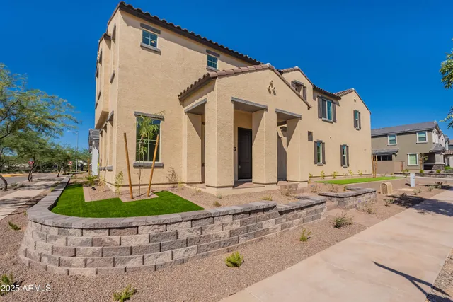 a view of a white house with a small yard and large tree