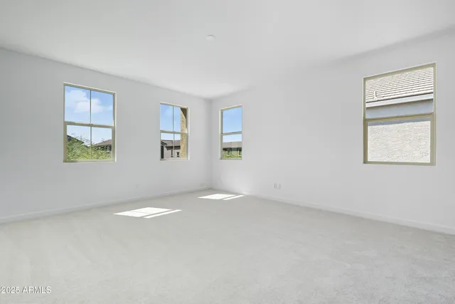 a view of a patio with table and chairs under an umbrella with large trees