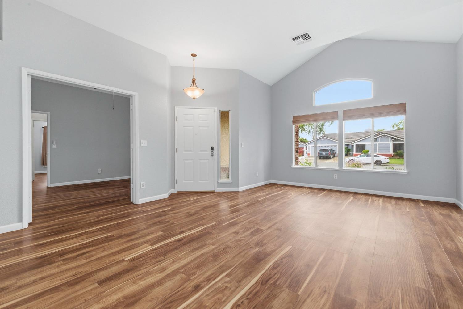 969 Colson Way Galt, CA 95632 - Photo 7 of 38 an empty room with wooden floor and windows