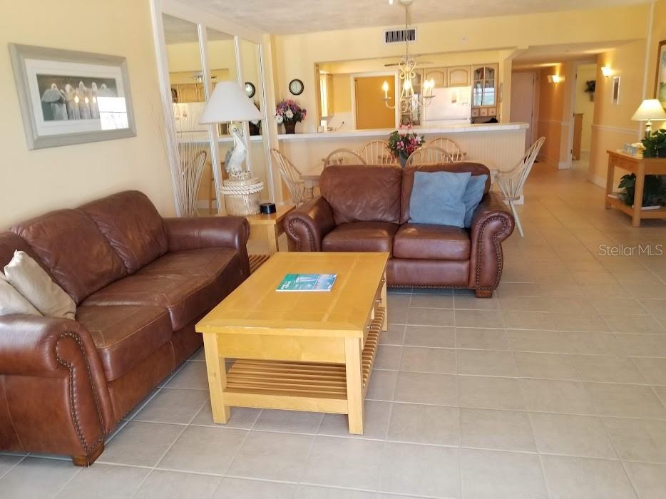 13650 Gulf Boulevard, Unit 304 Madeira Beach, FL 33708 - Photo 22 of 63 a living room with furniture a dining table and a view of kitchen