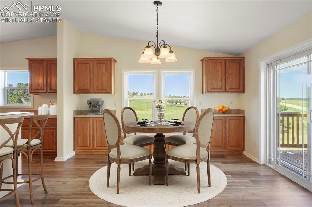 12825 Mc Cune Road Elbert, CO 80106 - Photo 20 of 50 a dining room with furniture a chandelier and wooden floor