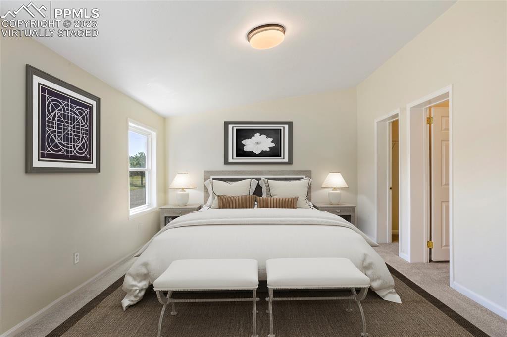 12825 Mc Cune Road Elbert, CO 80106 - Photo 36 of 50 a bedroom with a large bed and a desk