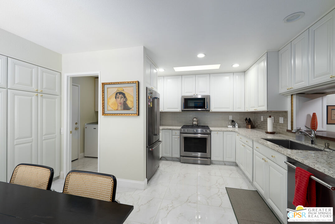 1142 East La Jolla Road Palm Springs, CA 92264 - Photo 12 of 35 a kitchen with stainless steel appliances granite countertop a refrigerator sink and stove