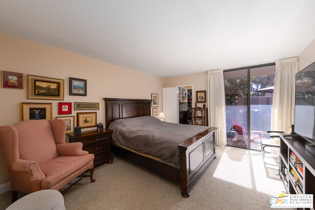 1142 East La Jolla Road Palm Springs, CA 92264 - Photo 20 of 35 a spacious bedroom with a bed a couch and a large window