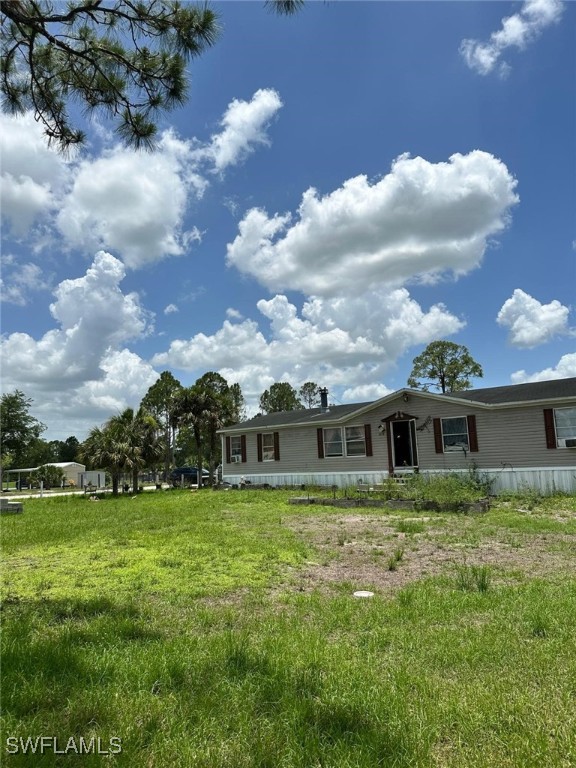 618 Hunting Club Avenue Clewiston, FL 33440 - Photo 3 of 32 a view of a house with a big yard and potted plants