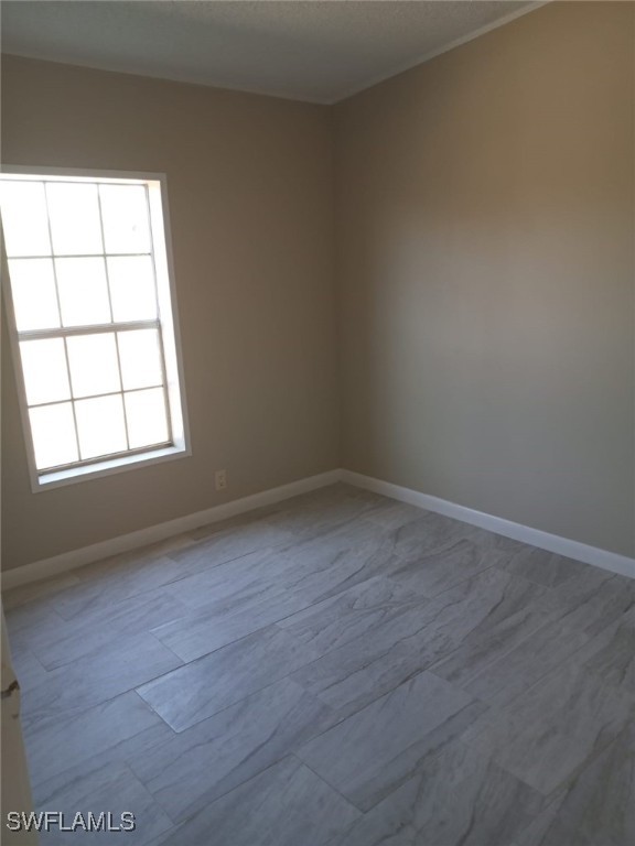 618 Hunting Club Avenue Clewiston, FL 33440 - Photo 7 of 32 an empty room with wooden floor and windows