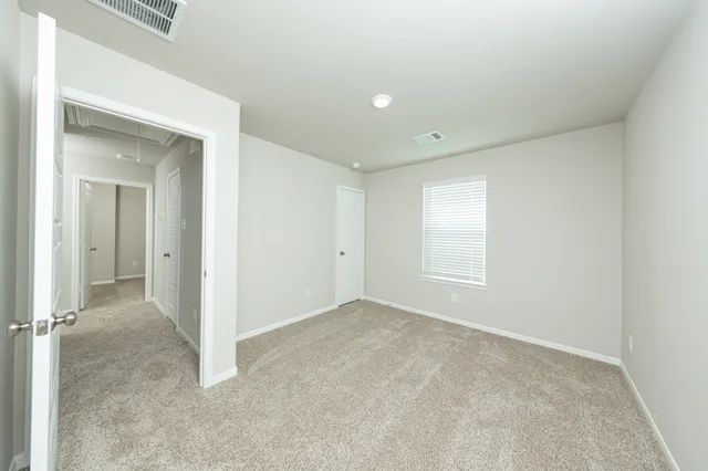 an empty room with windows and closet