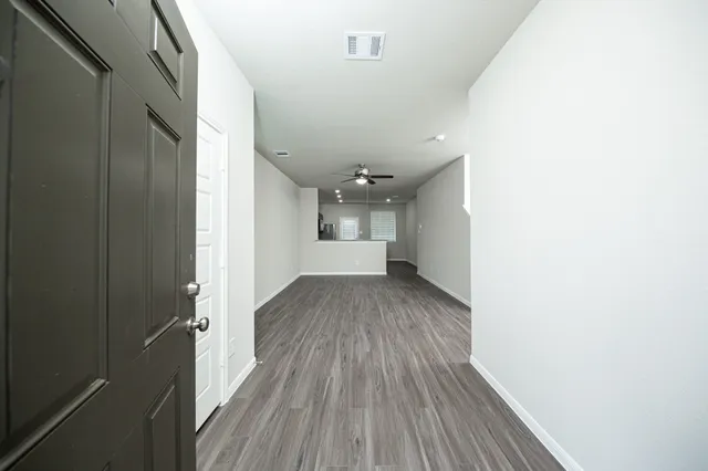 a view of empty room with wooden floor