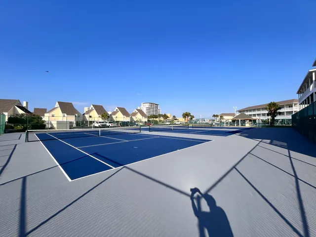 a balcony with wooden floor table and chairs