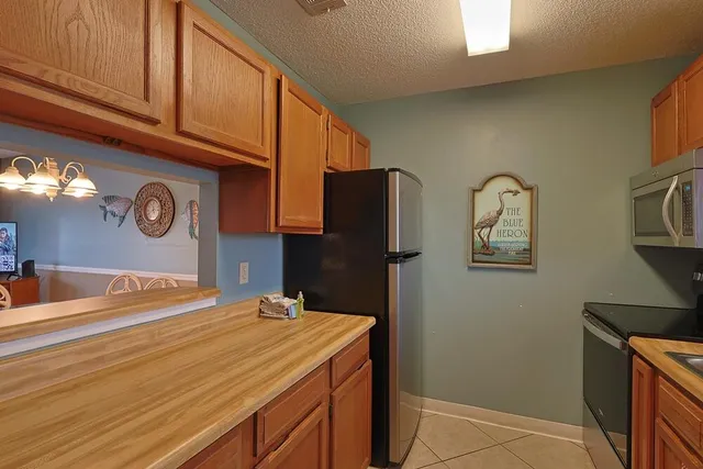 a view of a dining room with furniture a chandelier and large windows