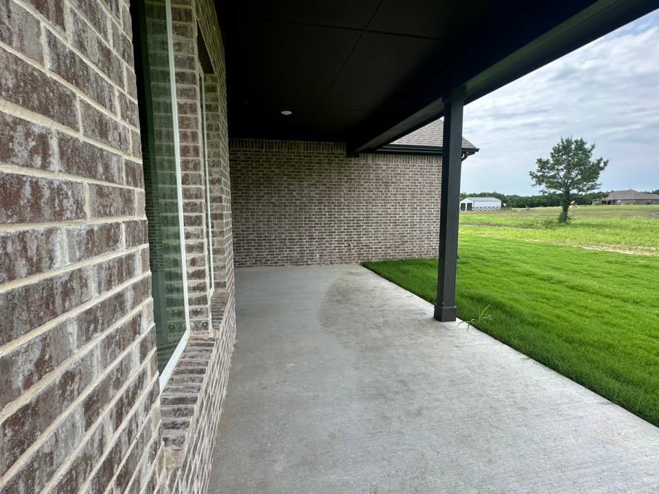 390 Cobb Road Leonard, TX 75452 - Photo 24 of 26 Covered concrete patio featuring a recessed light, brick exterior, and a manicured lawn