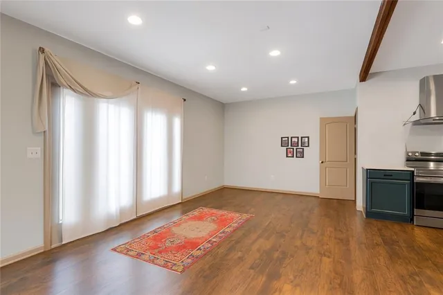 a view of a big room with wooden floor and windows