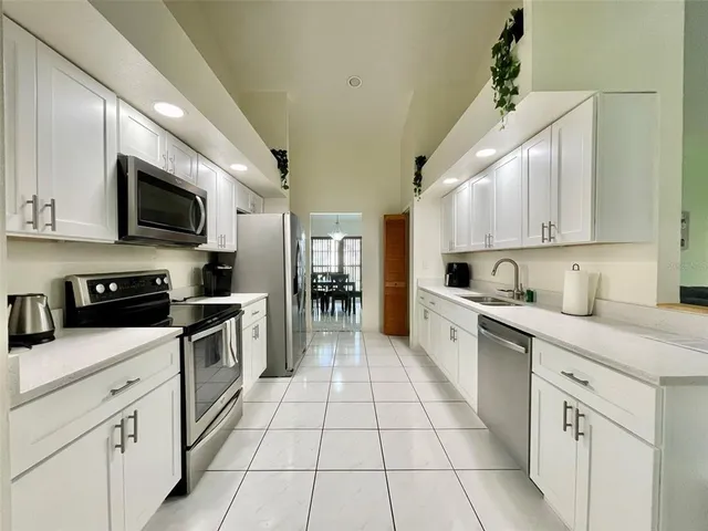 a large kitchen with cabinets stainless steel appliances and a counter space