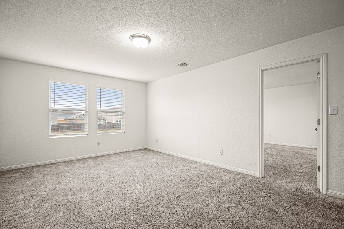 109 Gray Fox Loop Hutto, TX 78634 - Photo 9 of 28 Unfurnished room with a textured ceiling and light colored carpet
