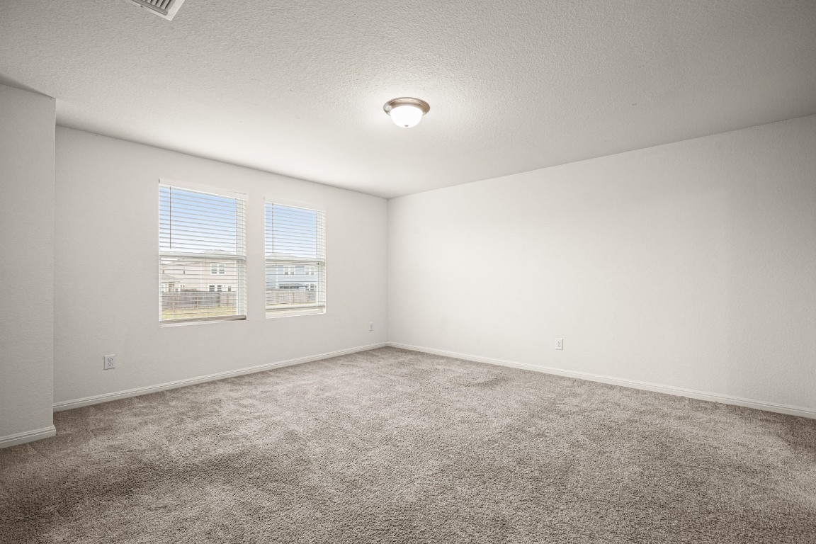 109 Gray Fox Loop Hutto, TX 78634 - Photo 10 of 28 Empty room with a textured ceiling and light carpet
